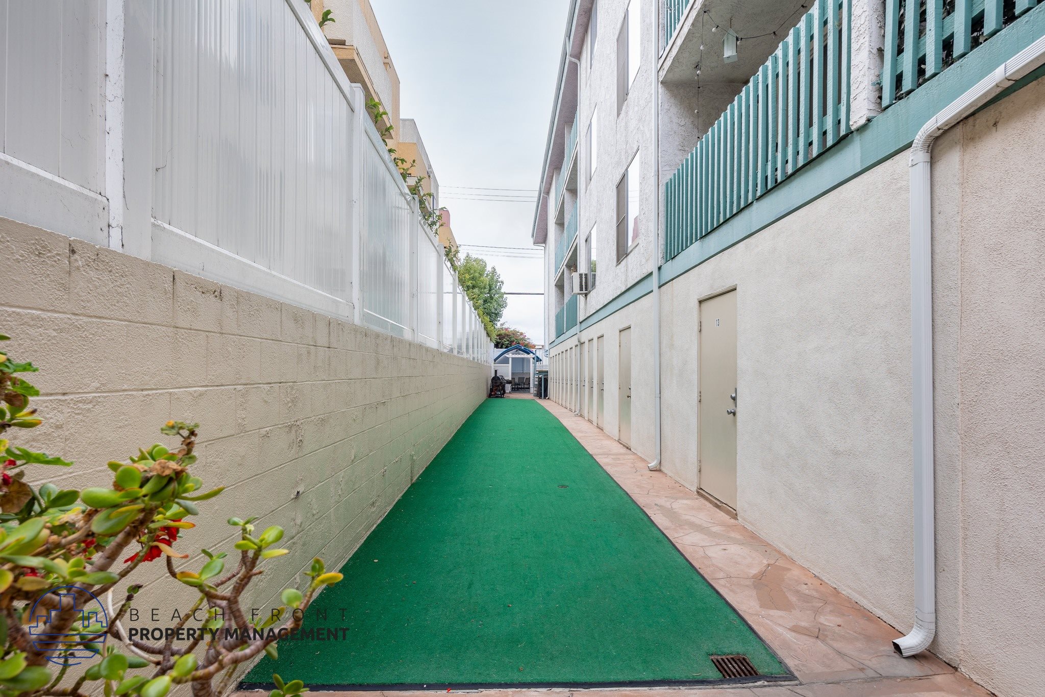 A narrow alley with a green pathway and white walls.