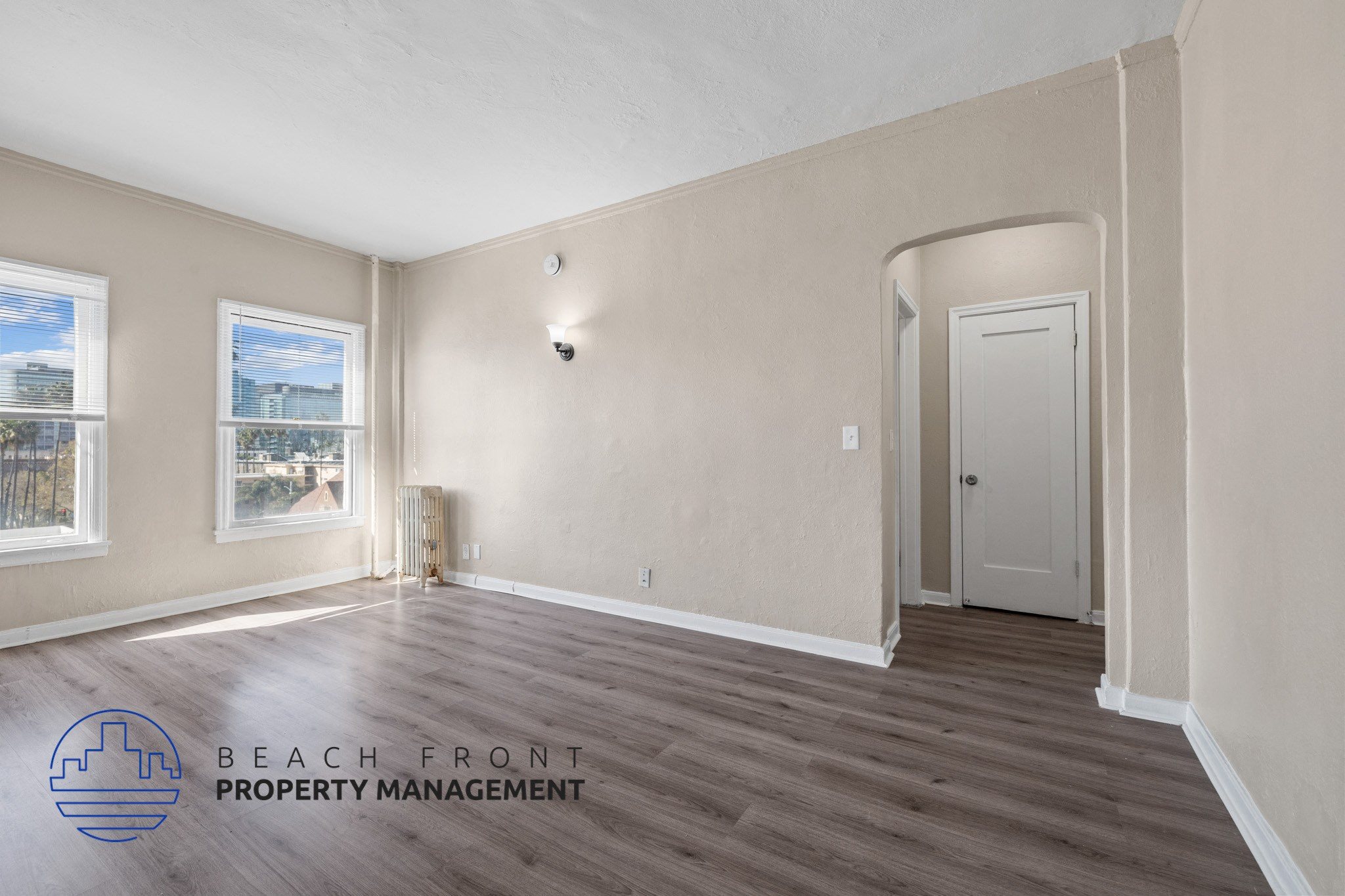 A room with a window and a door is managed by Beach Front Property Management.