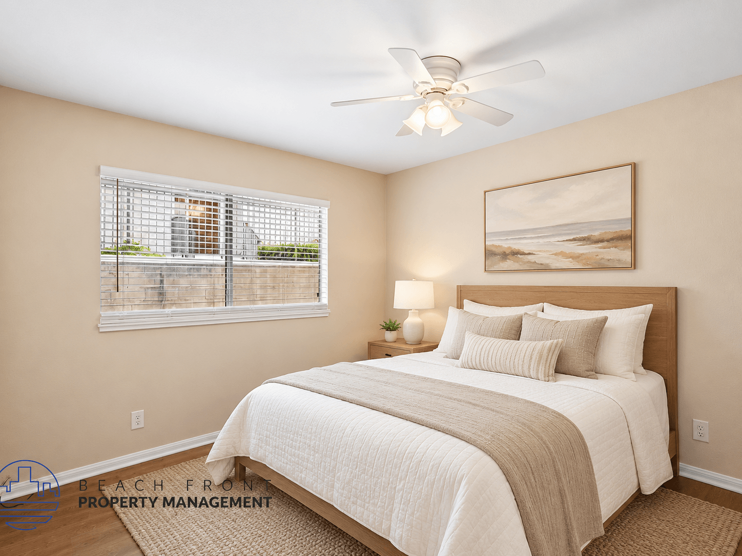 A bedroom with a large bed and a painting of a beach scene on the wall.