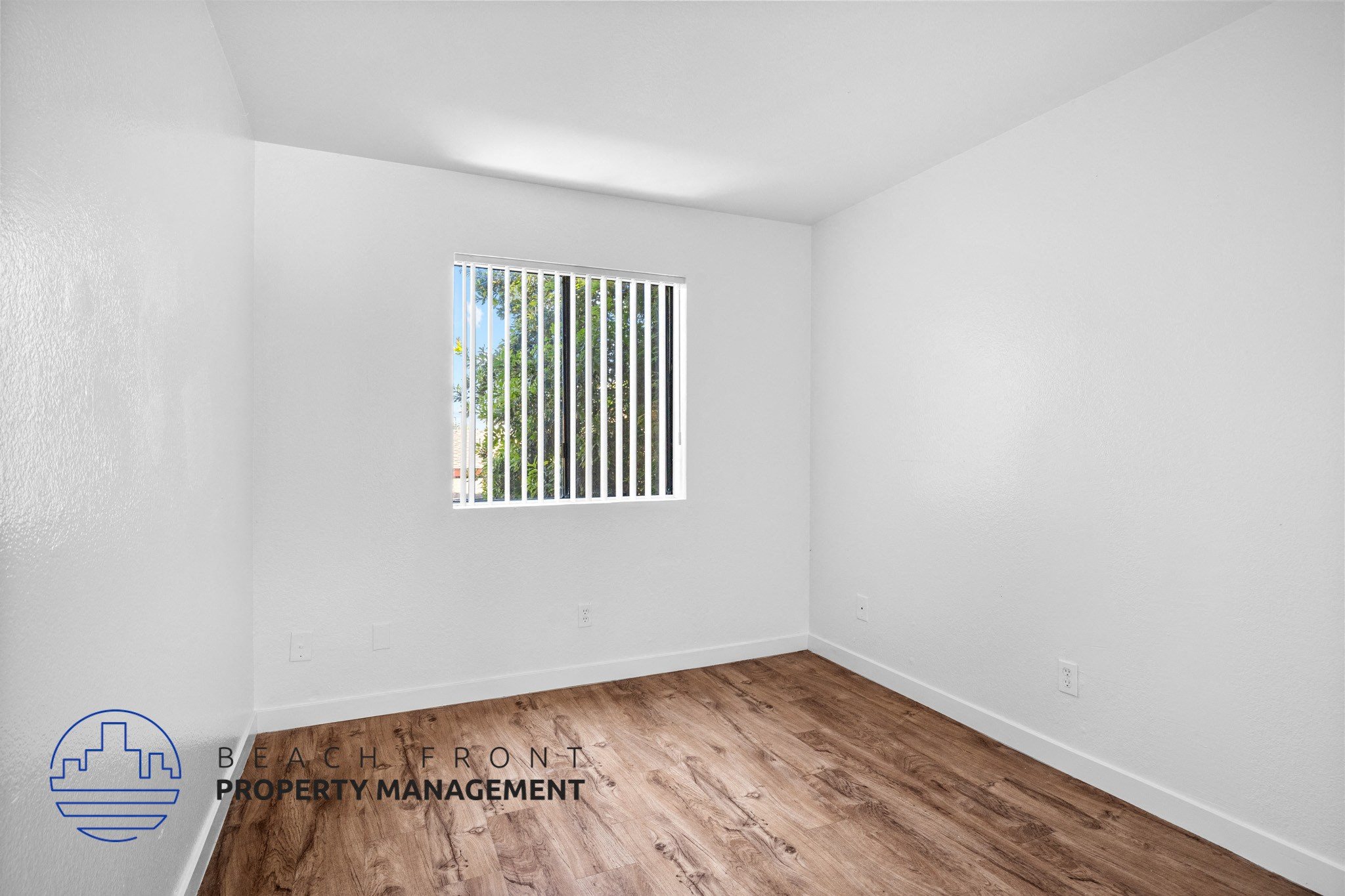 the living room of an apartment with wood flooring and a window,the living room of an apartment with wood flooring and a window