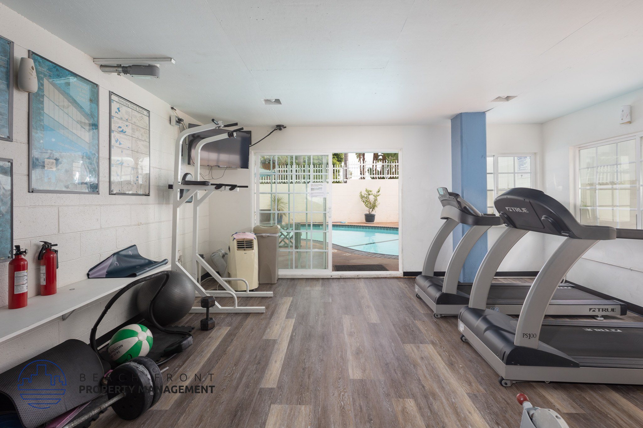 A gym with treadmills, weights, and exercise equipment.
