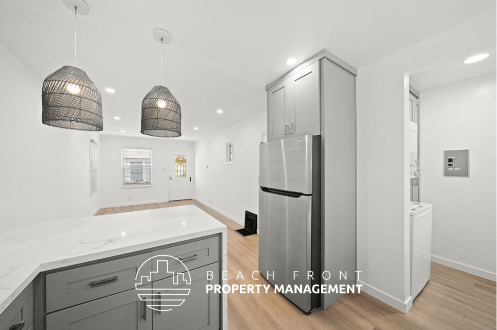 a kitchen with a white counter top and a stainless steel refrigerator
