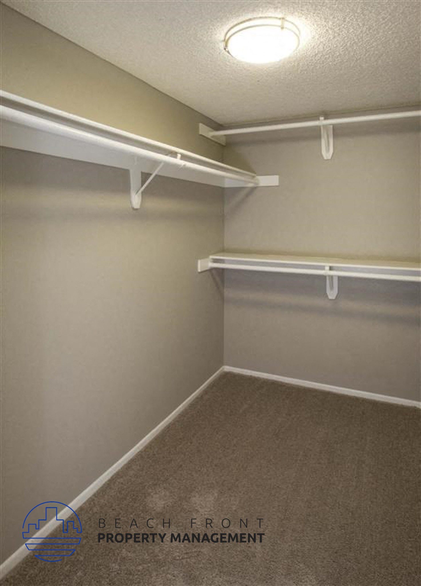 A small, empty closet with a carpeted floor and white shelving.