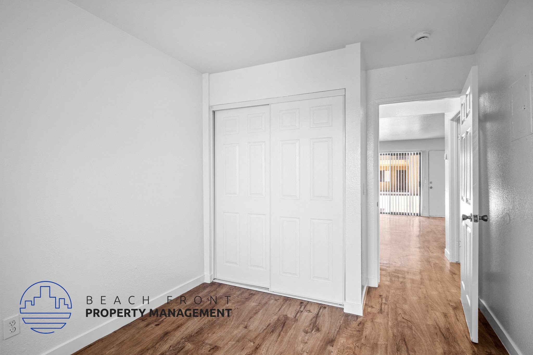 a bedroom with a white door and a hallway with a wood floor,a bedroom with a white door and a hallway with a wood floor