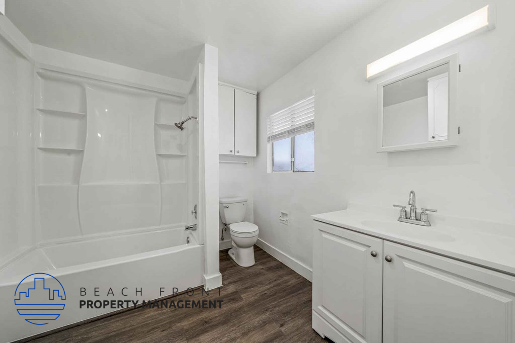 A white bathroom with a toilet, sink, and bathtub.