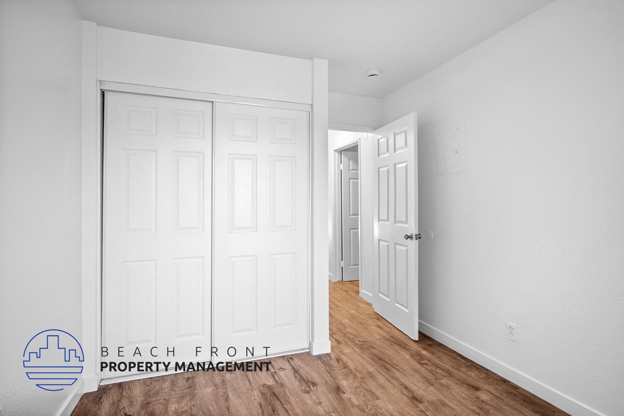 a bedroom with two closets and a door to a hallway,a bedroom with two closets and a door to a hallway