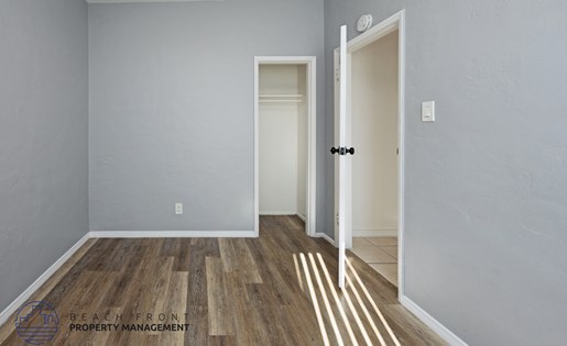 A room with wooden flooring and two white doors.