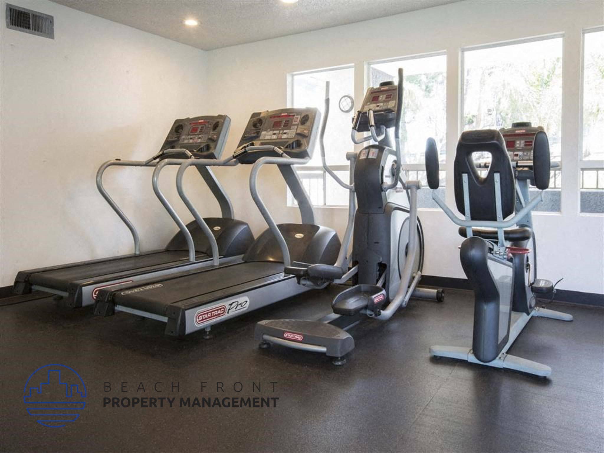 A gym with treadmills, exercise bikes, and elliptical machines.