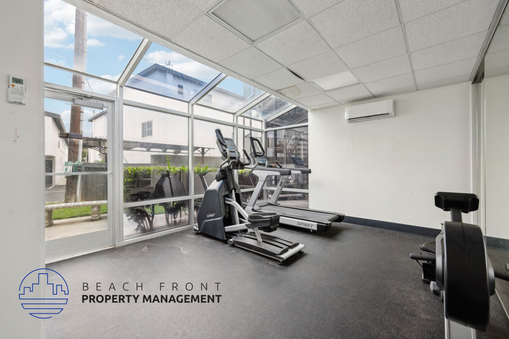 A gym room with a view of the outside through the windows.