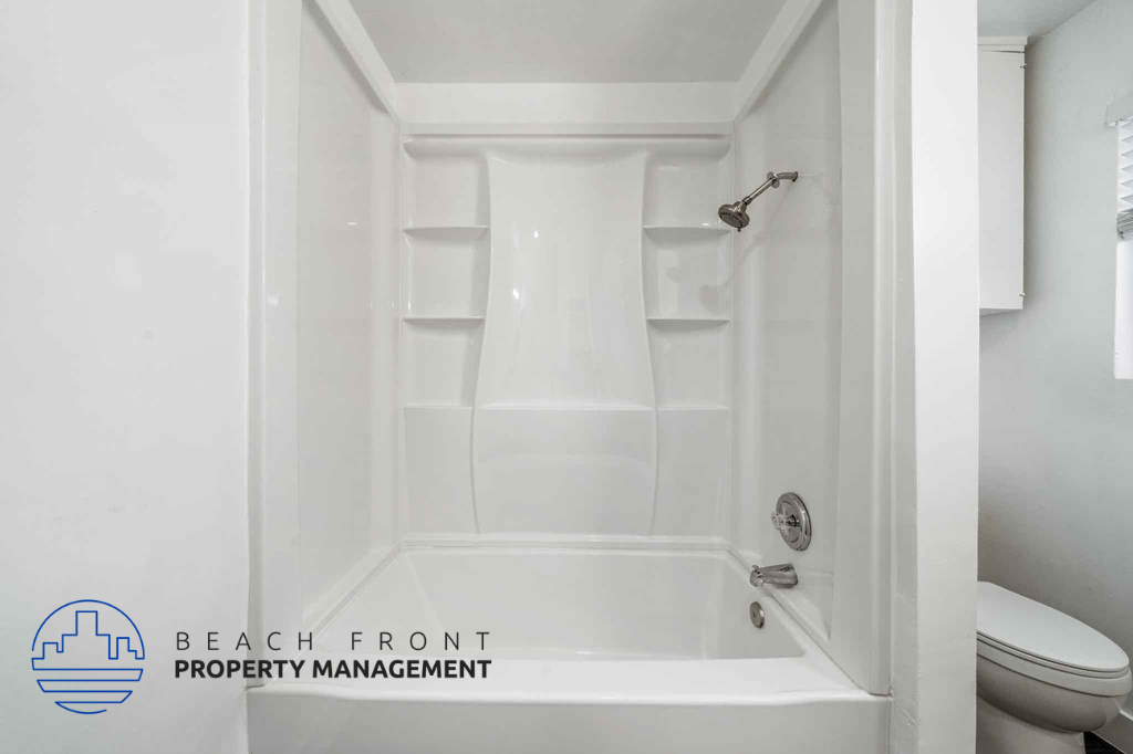 A white bathroom with a shower and toilet.