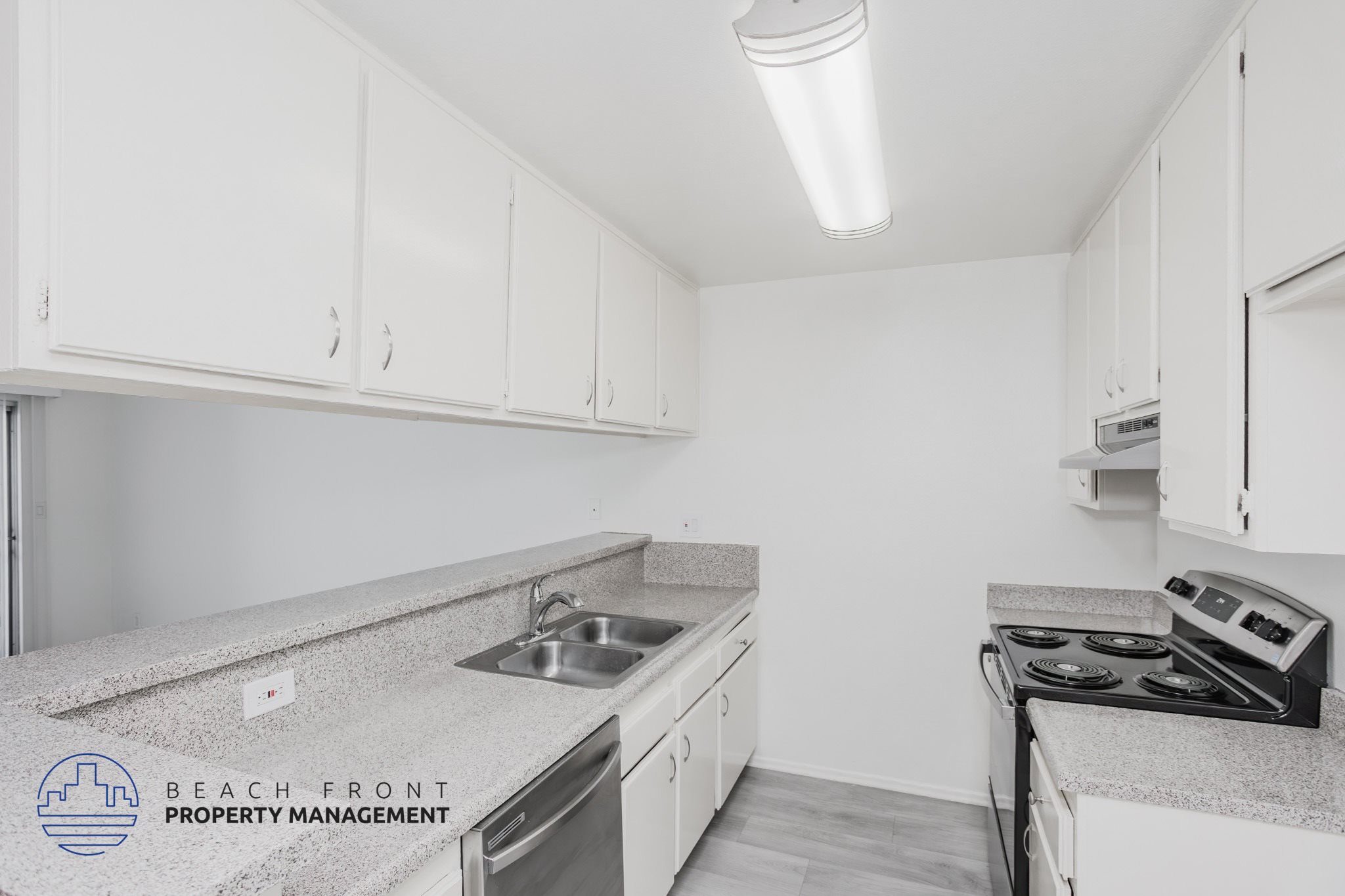 A kitchen with white cabinets and a granite countertop.