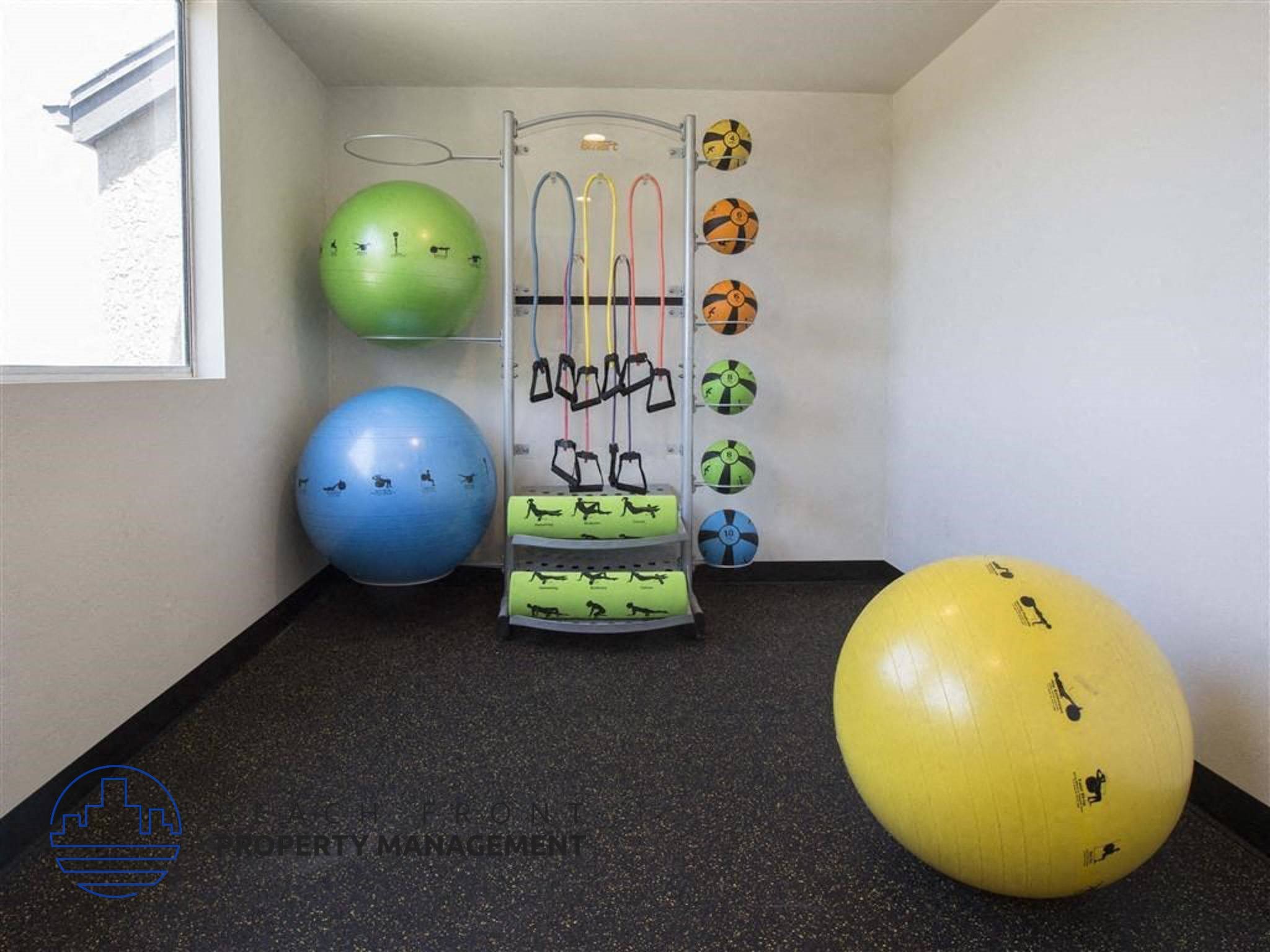 A gym with a blue ball, a green ball, and a yellow ball.