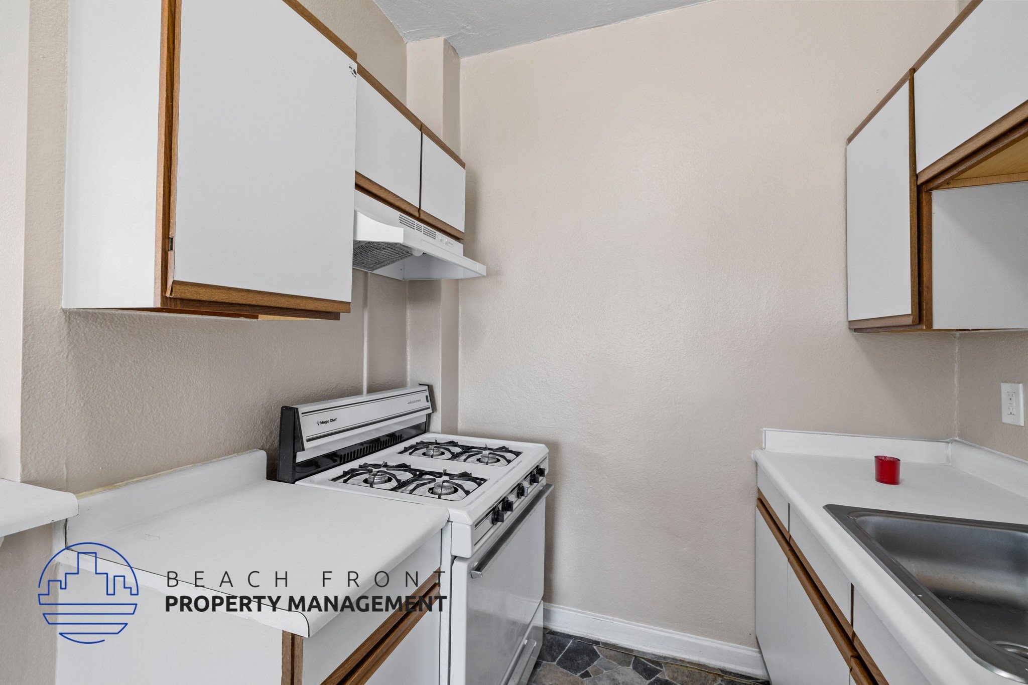 A kitchen with white cabinets and a stove top oven.