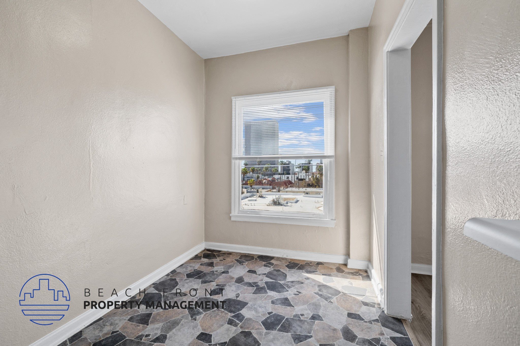 A room with a view of a cityscape through a window.