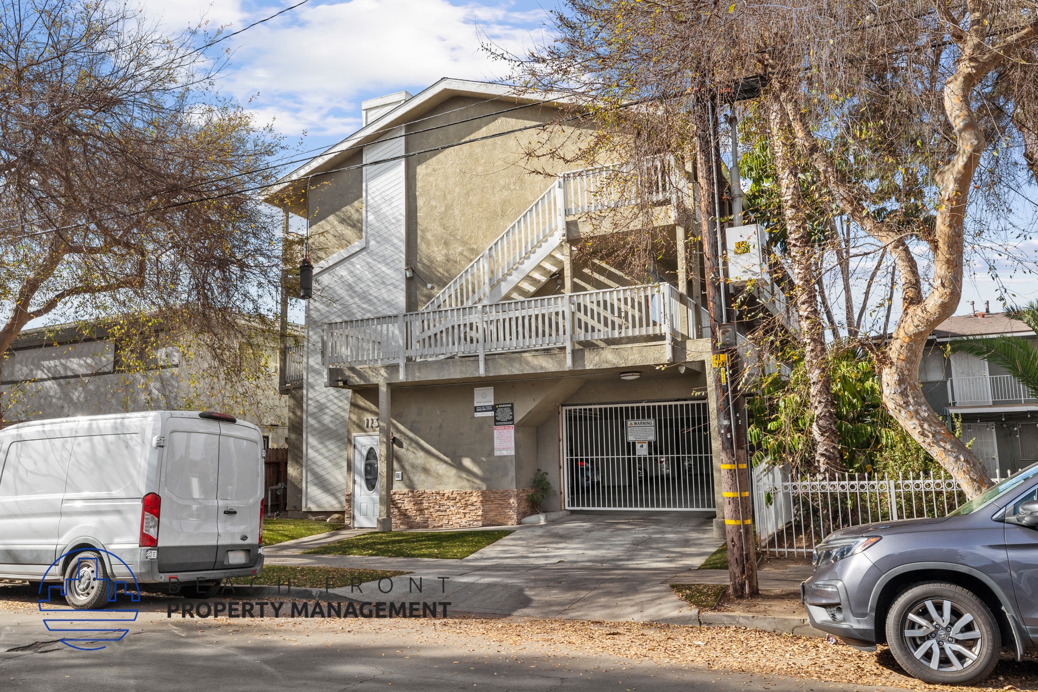 A white van is parked in front of a building with a sign that reads "Front Property Management.".