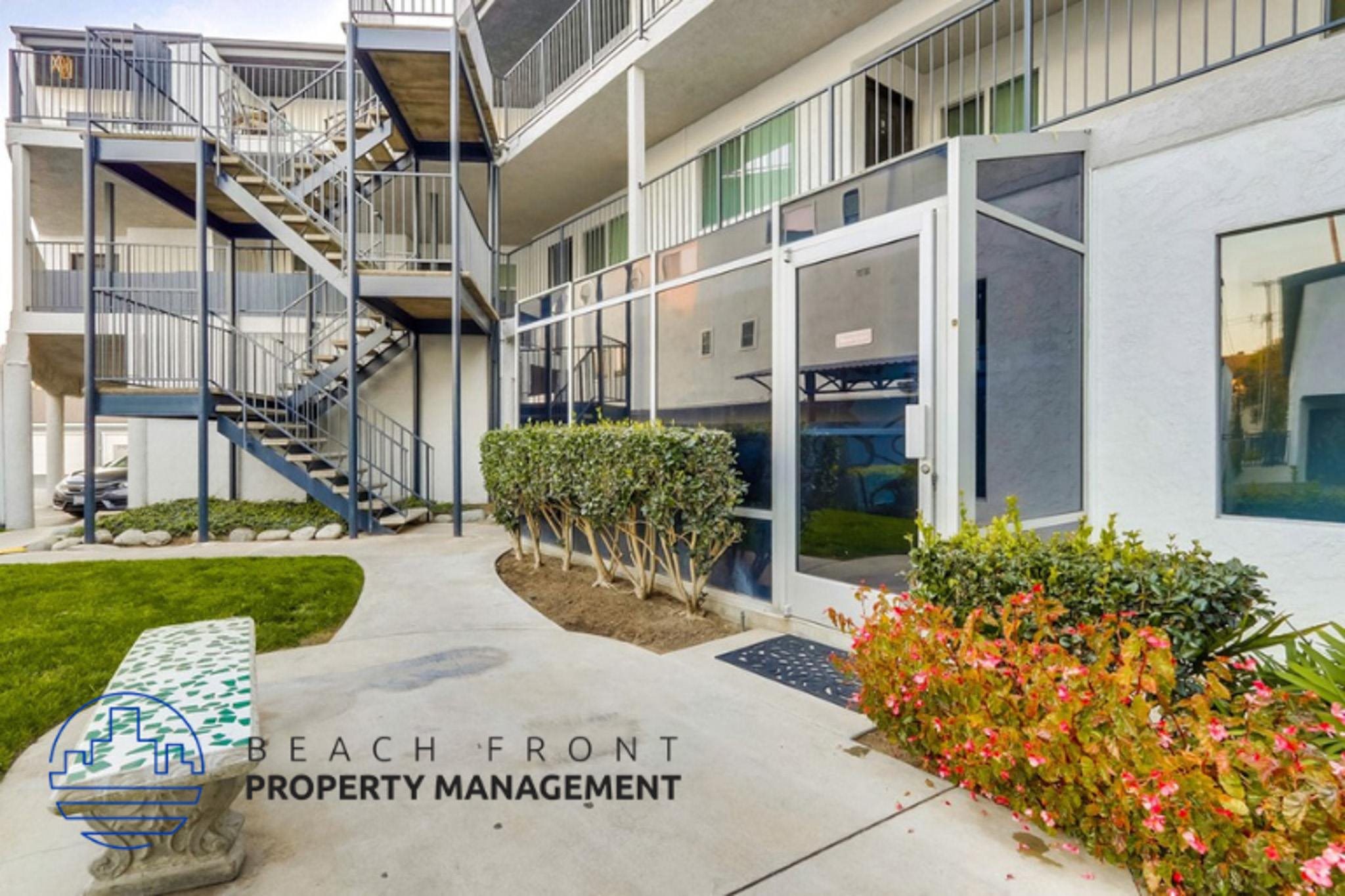a view of the entrance to a beach front property management building with stairs and plants