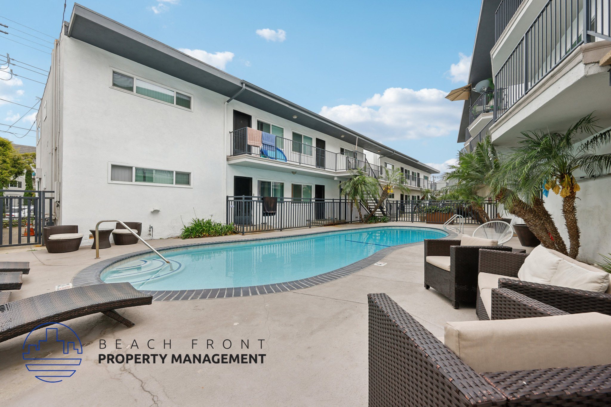 A pool area with lounge chairs and a building in the background.