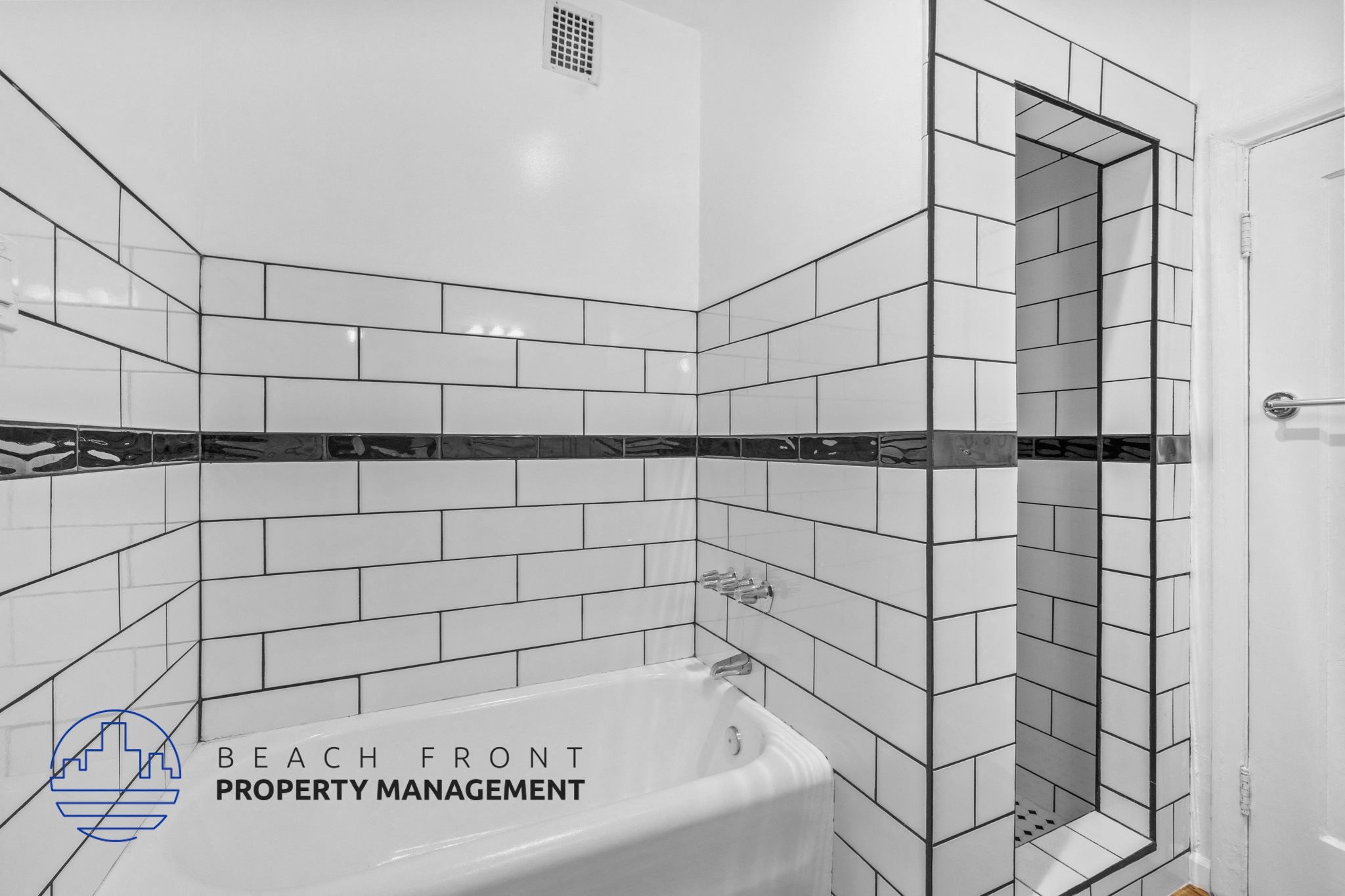 a white tiled bathroom with a tub and a shower