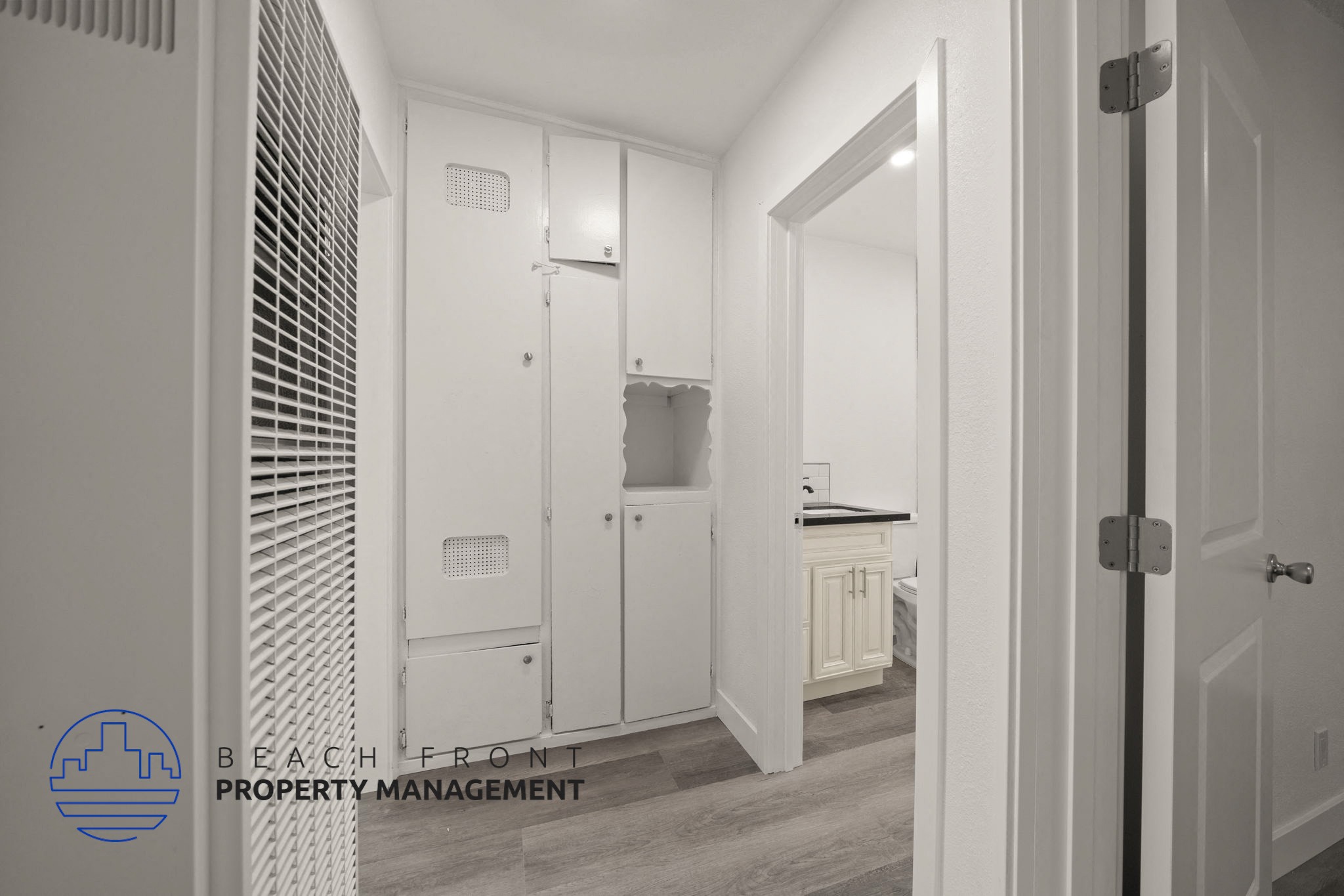 A hallway with a logo for Beach Front Property Management in the bottom left corner.