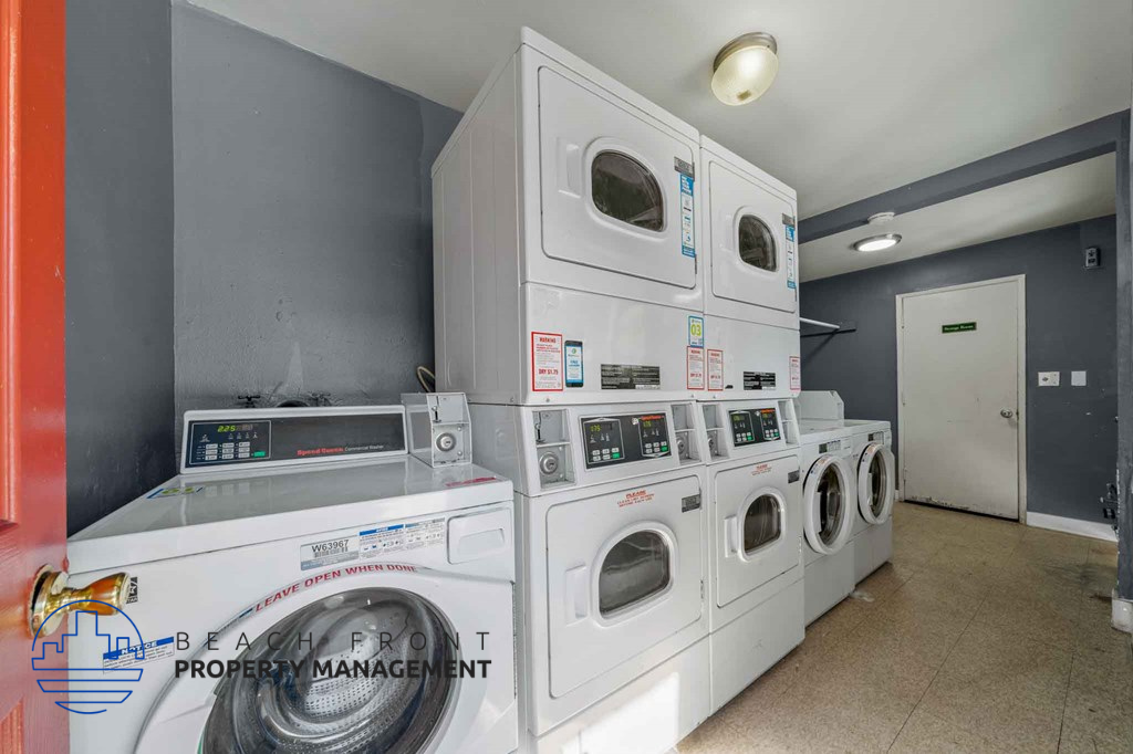 A stack of white front load washing machines in a laundry room.