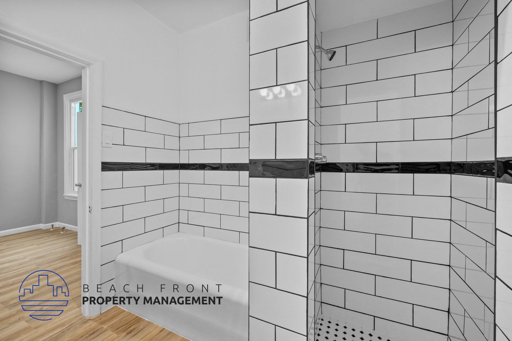 a white tiled shower in a bathroom with a wood floor