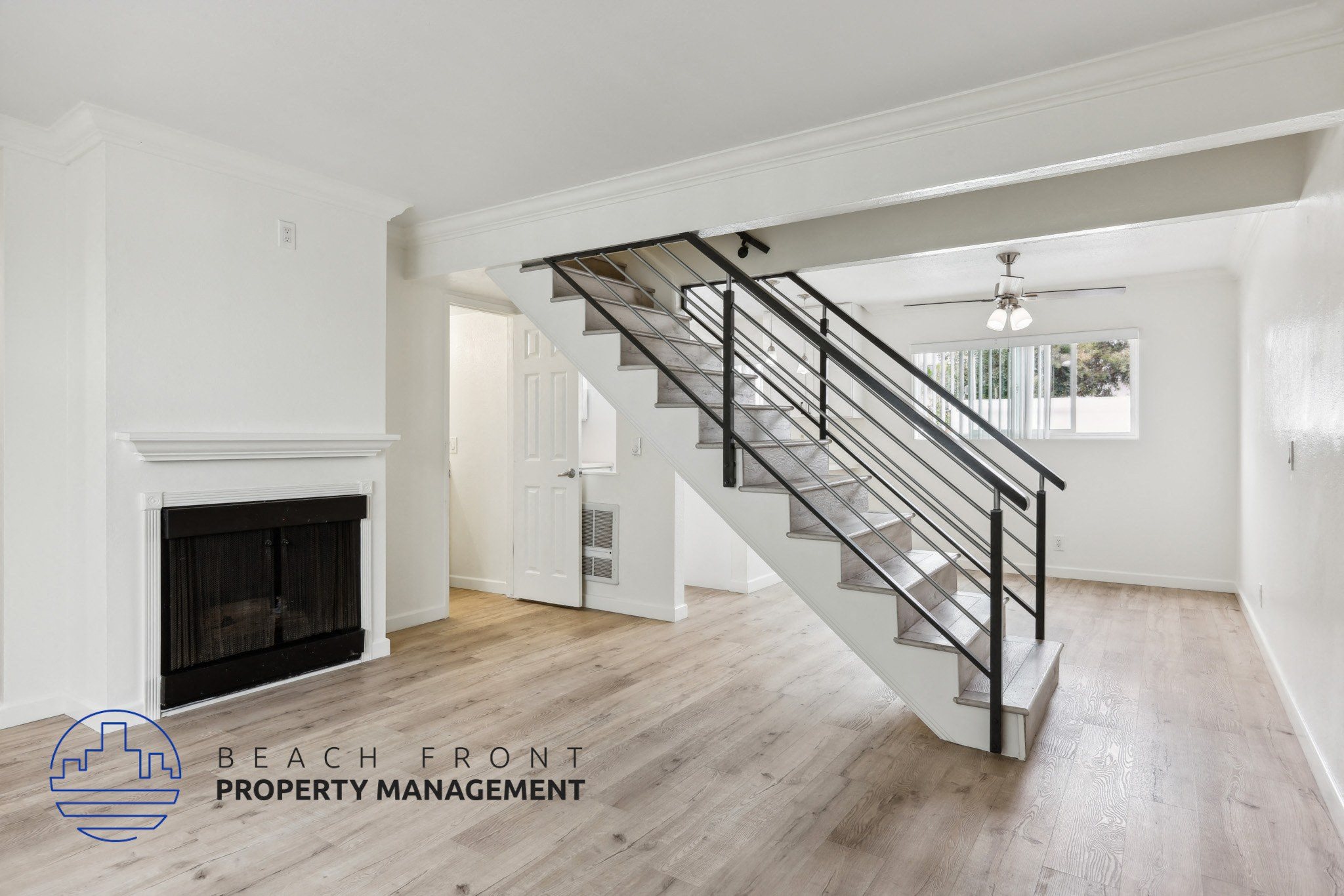 A spacious room with a staircase leading to the upper floor.