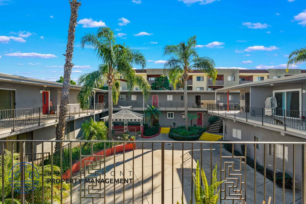 A sunny day at the property management building with palm trees and a clear blue sky.