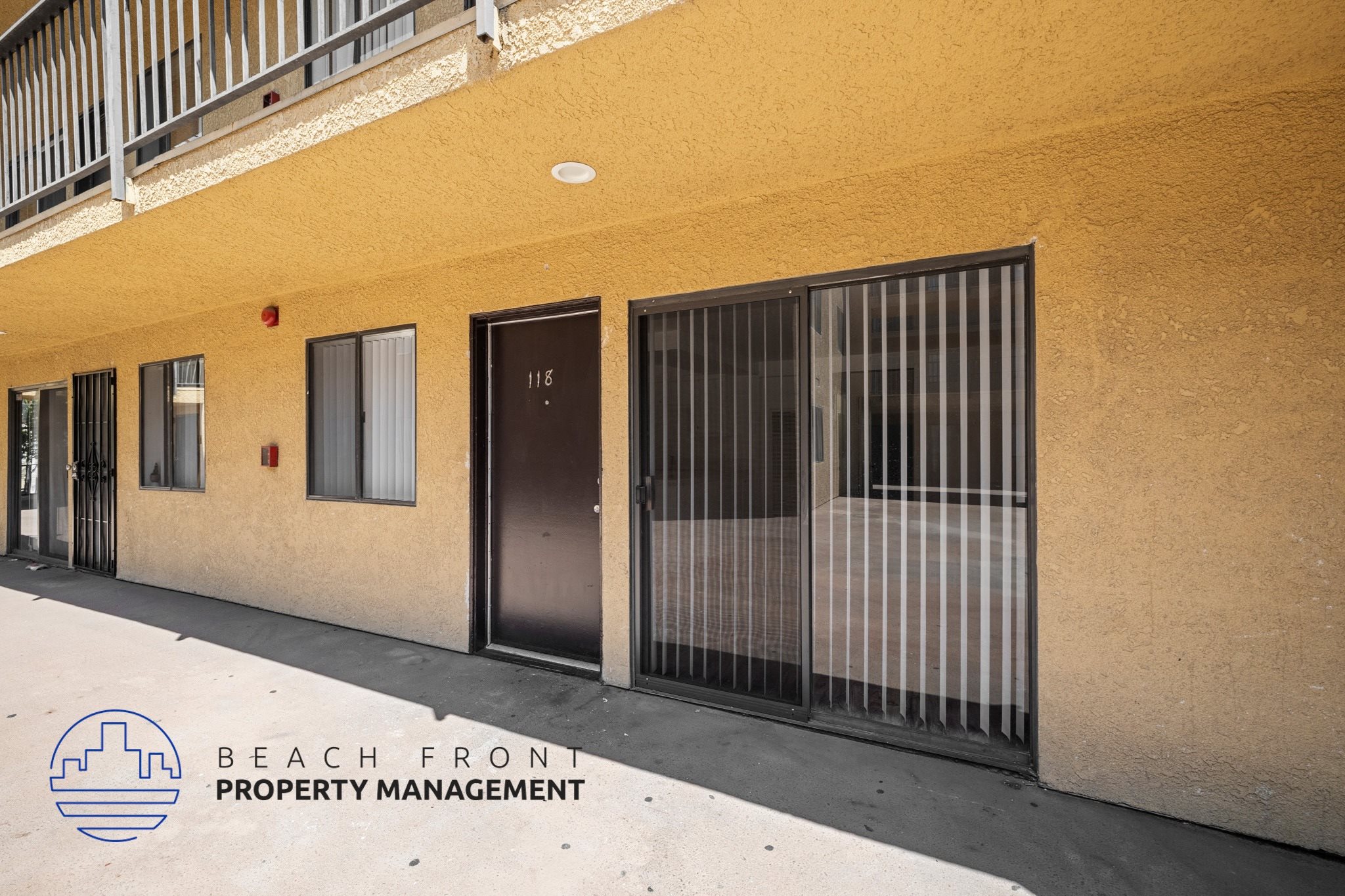 A building with a balcony and a sign that says Beach Front Property Management.