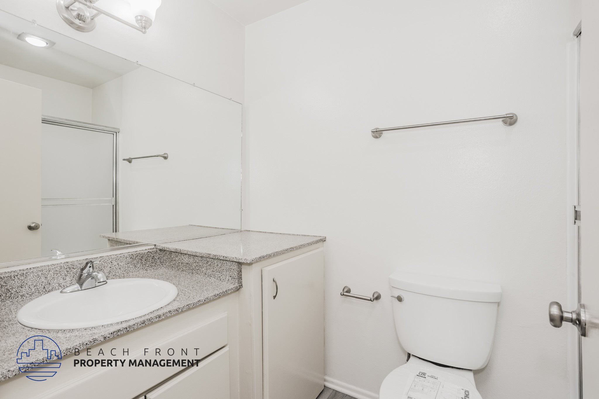 A white toilet sits next to a white sink in a small bathroom.