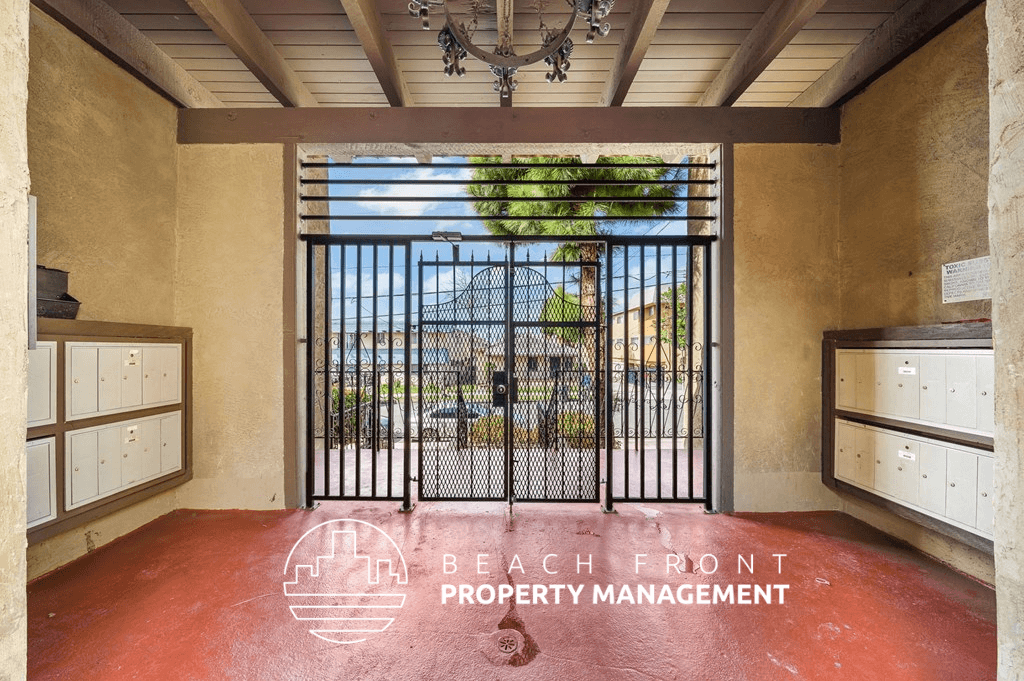 a view of the beach from a property management office with a gate and a window