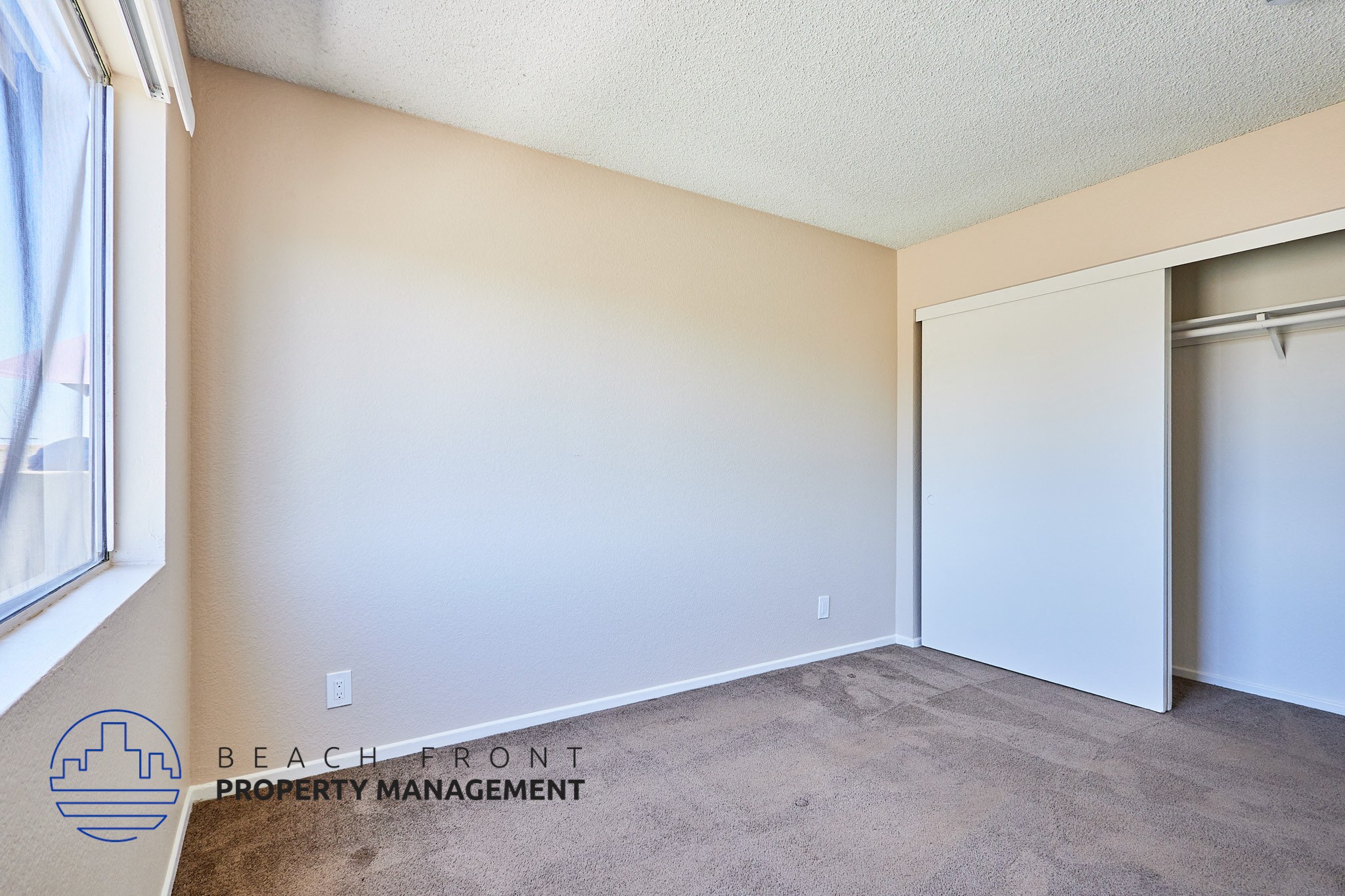 A room with a carpeted floor and a sliding door.