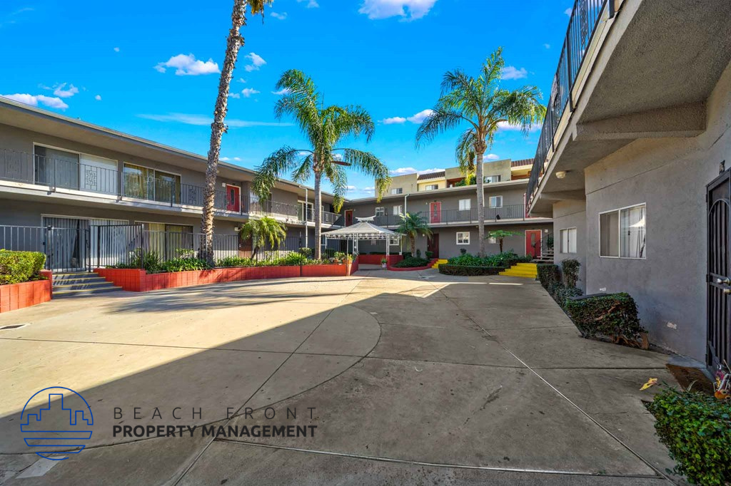 A sunny day at the beachfront property with palm trees and apartments.