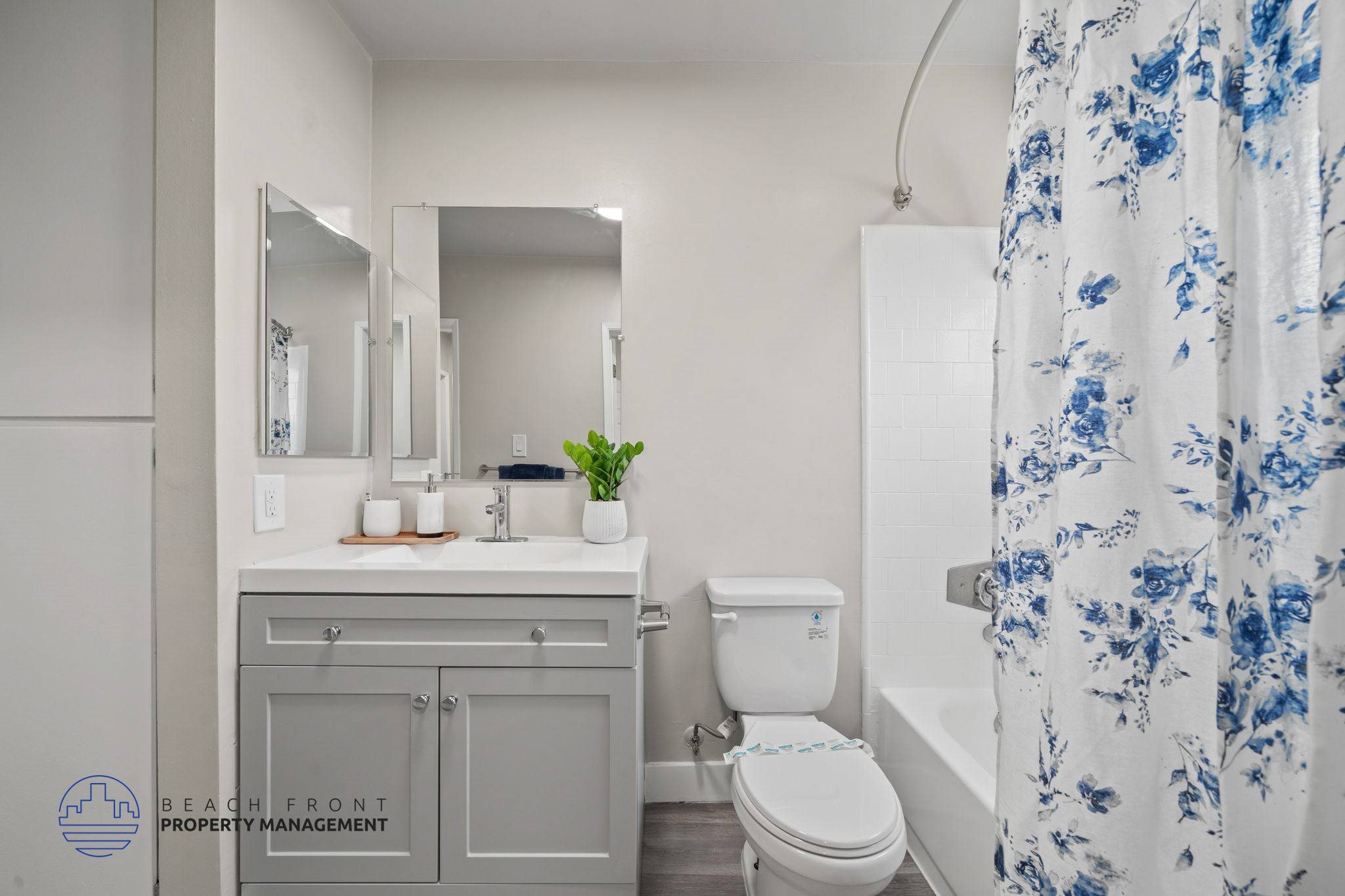 A bathroom with a white toilet, sink, and shower curtain.