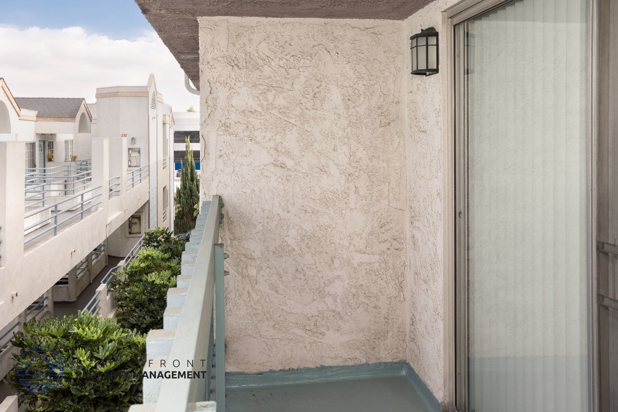 A balcony with a railing and a wall with a window.