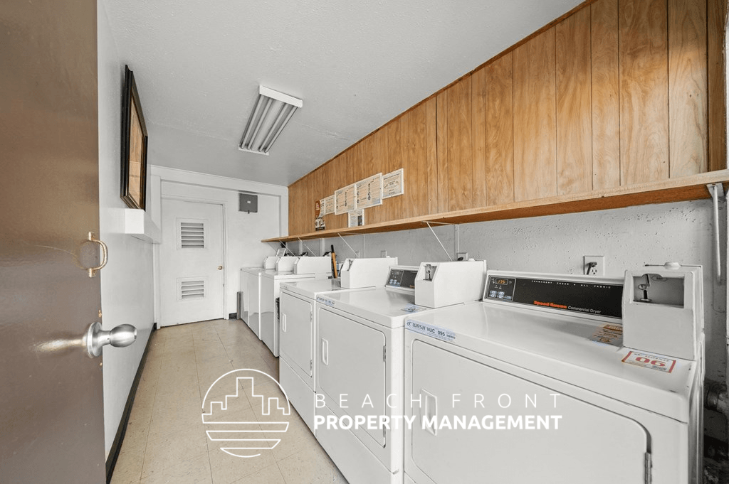 a laundry room with four washer and dryers in it and wooden cabinets