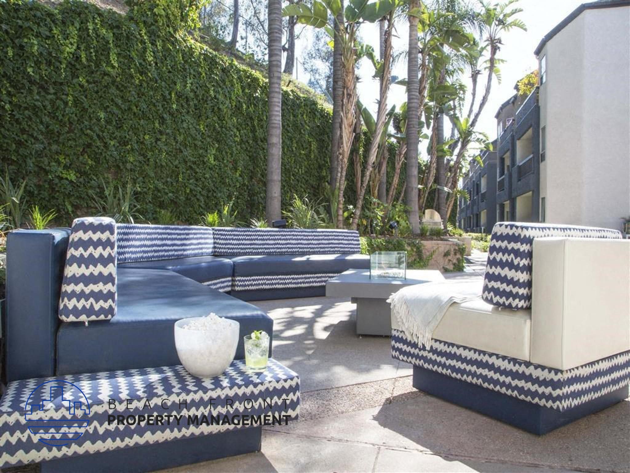 an outdoor lounge area with blue and white furniture and plants