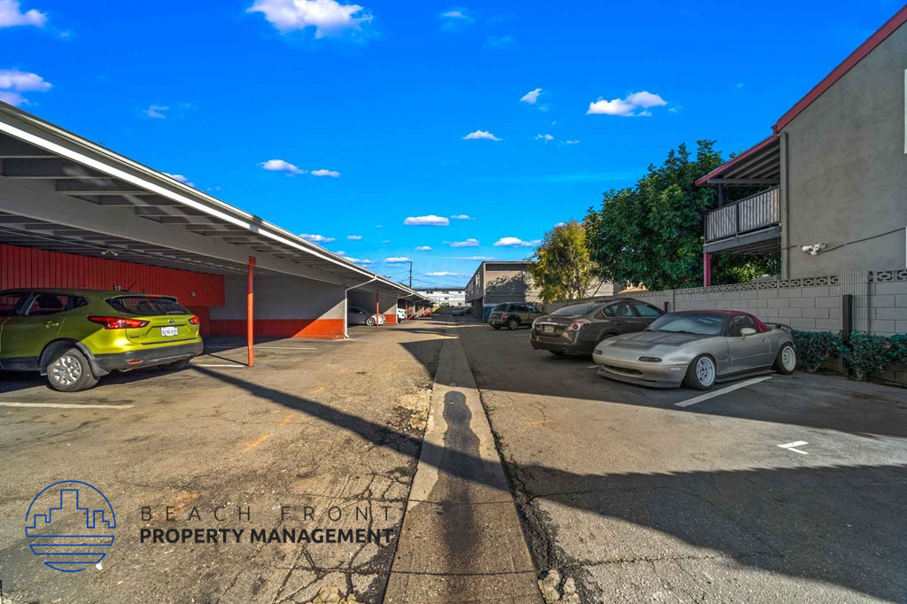 A parking lot with cars and a building in the background.