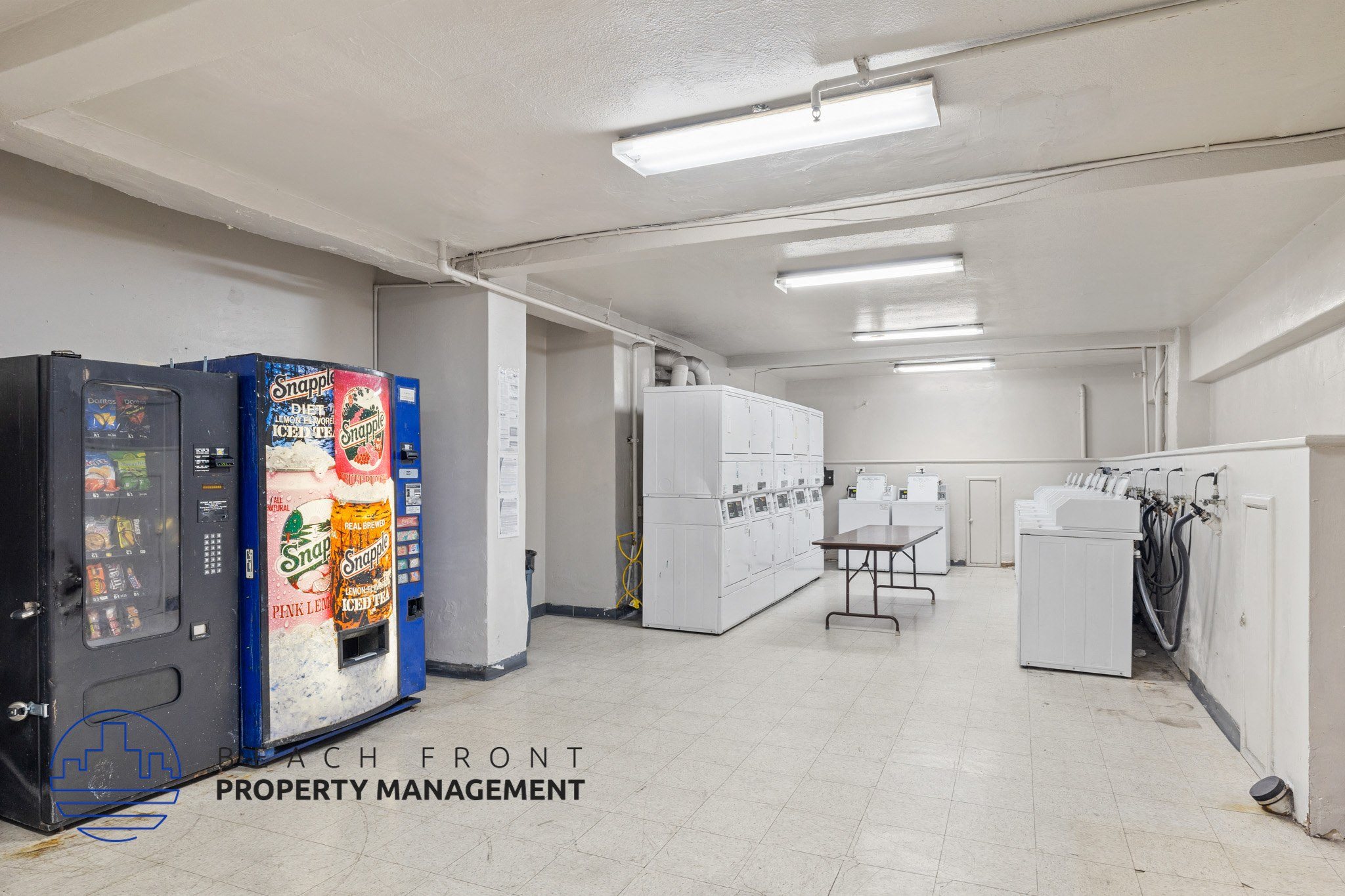 A vending machine selling Mountain Dew is in a large, empty room.