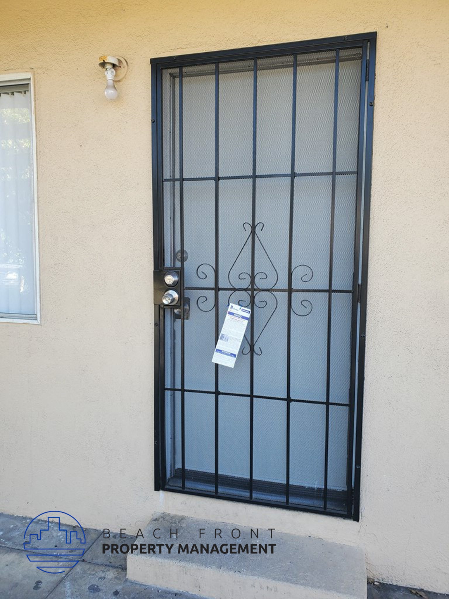 a black wrought iron door with a sign on it