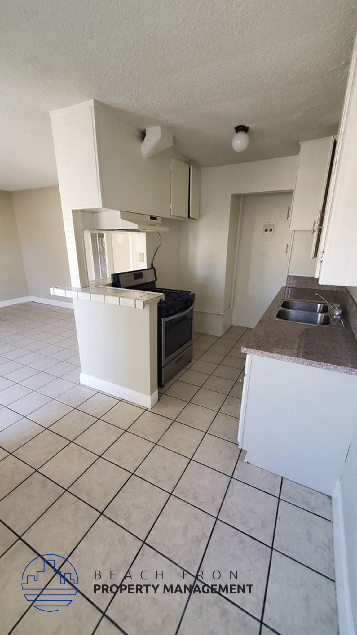 an empty kitchen with a stove and a sink
