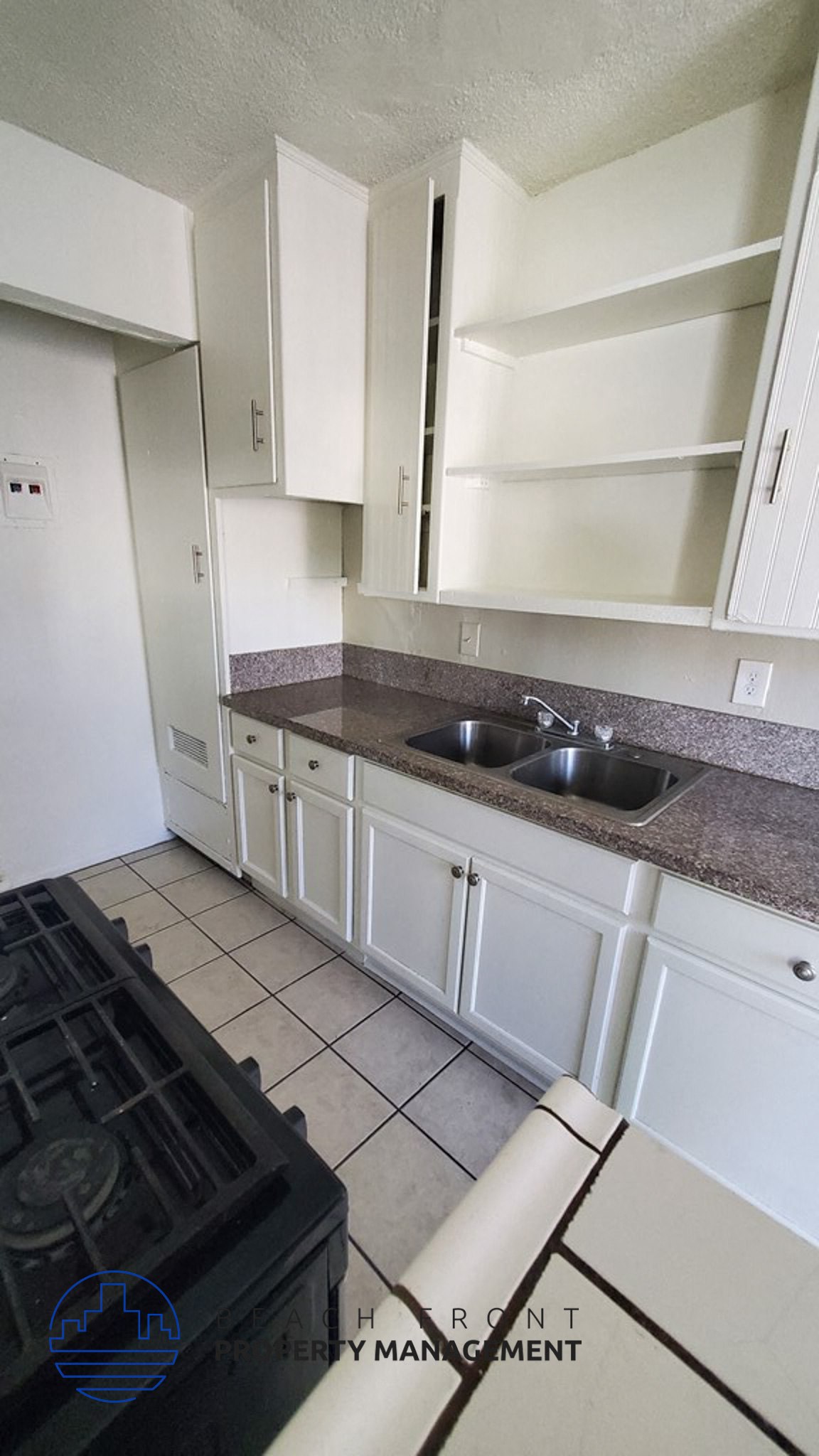 an empty kitchen with white cabinets and a sink