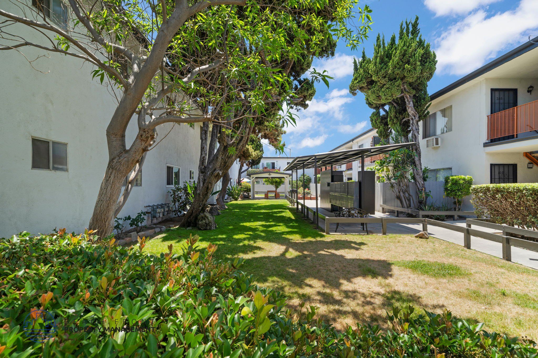 A white building with a tree in front of it.