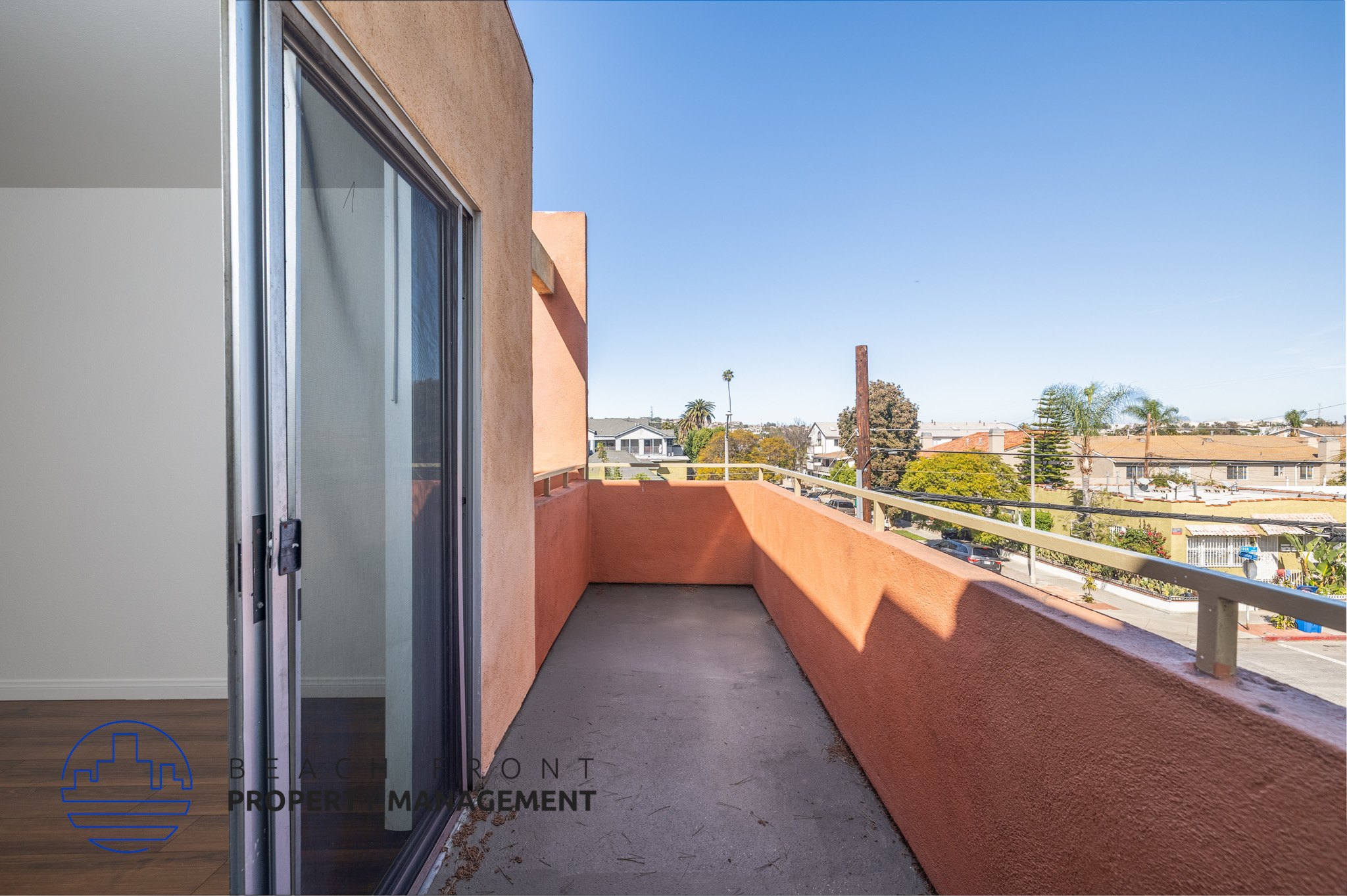 A balcony with a glass door and a view of the street below.