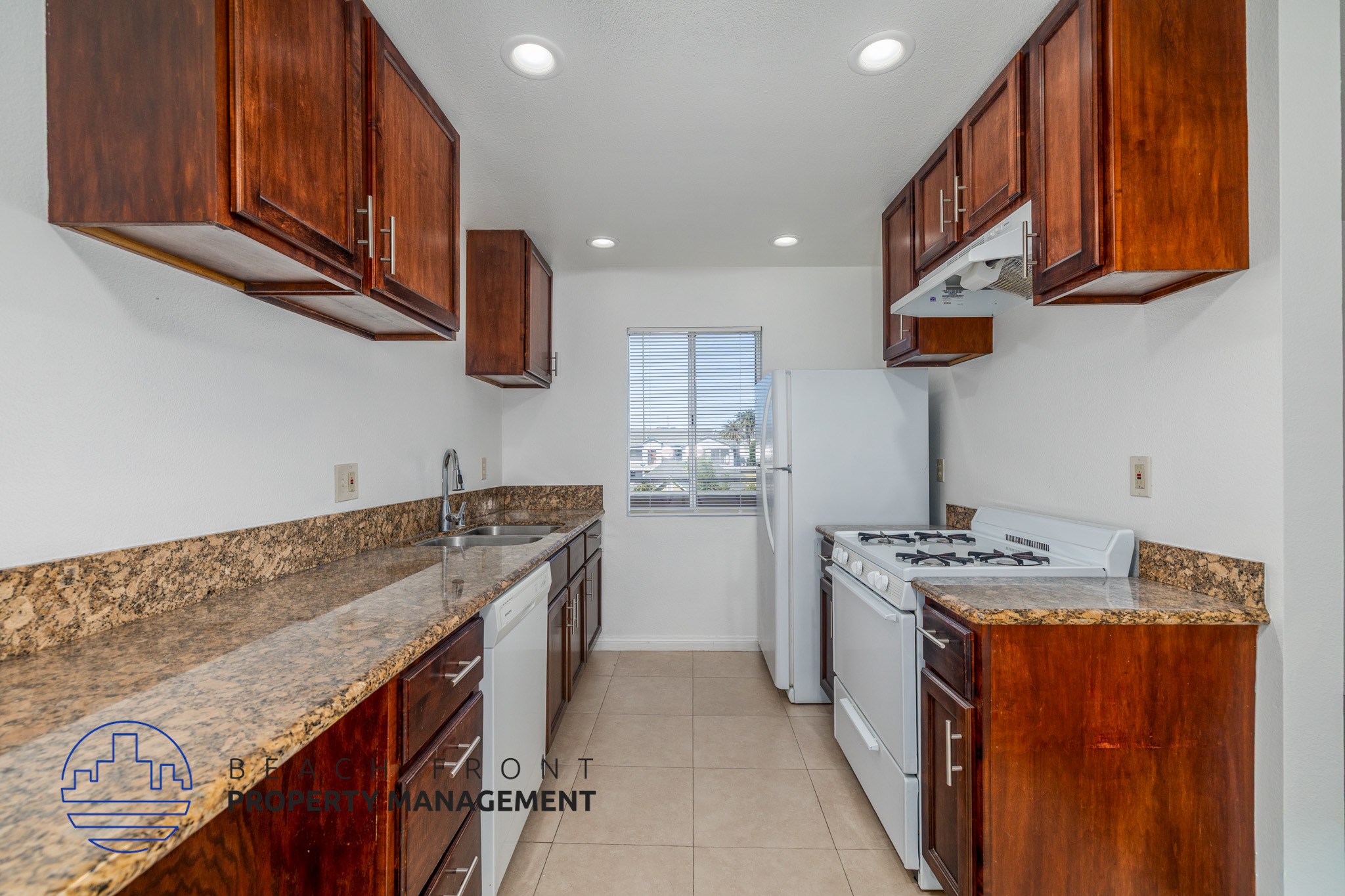 A kitchen with wooden cabinets and a granite countertop.
