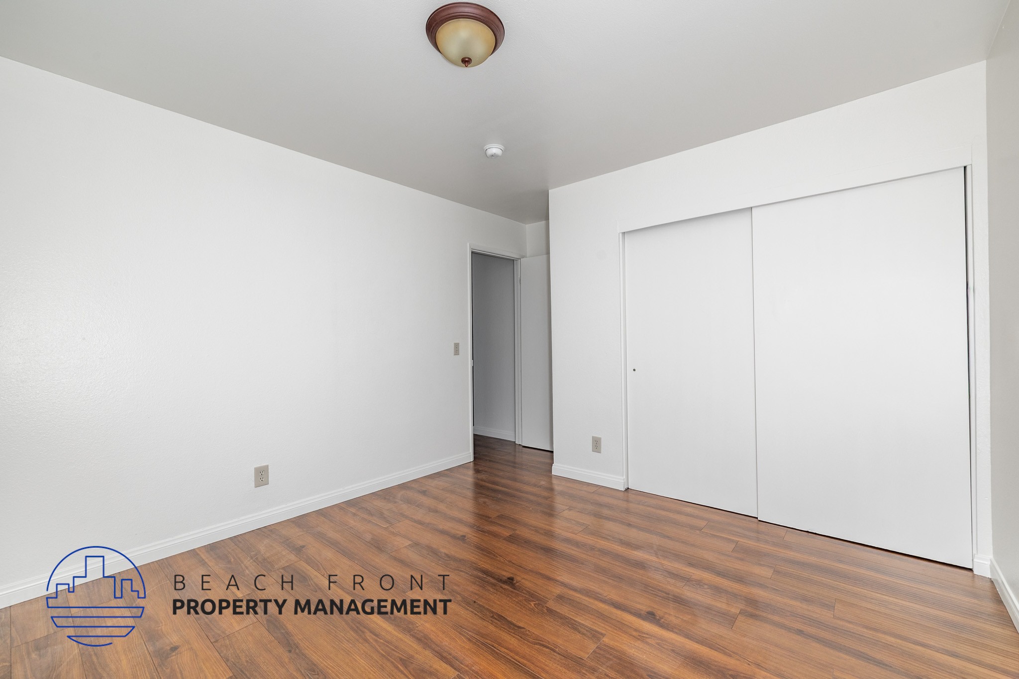 A room with a logo of Beach Front Property Management on the floor.