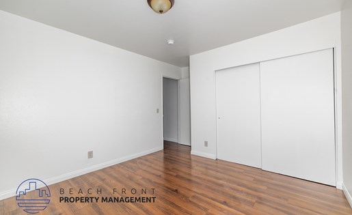 A room with a logo of Beach Front Property Management on the floor.