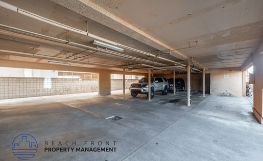A large, empty parking garage with a car parked in the middle.