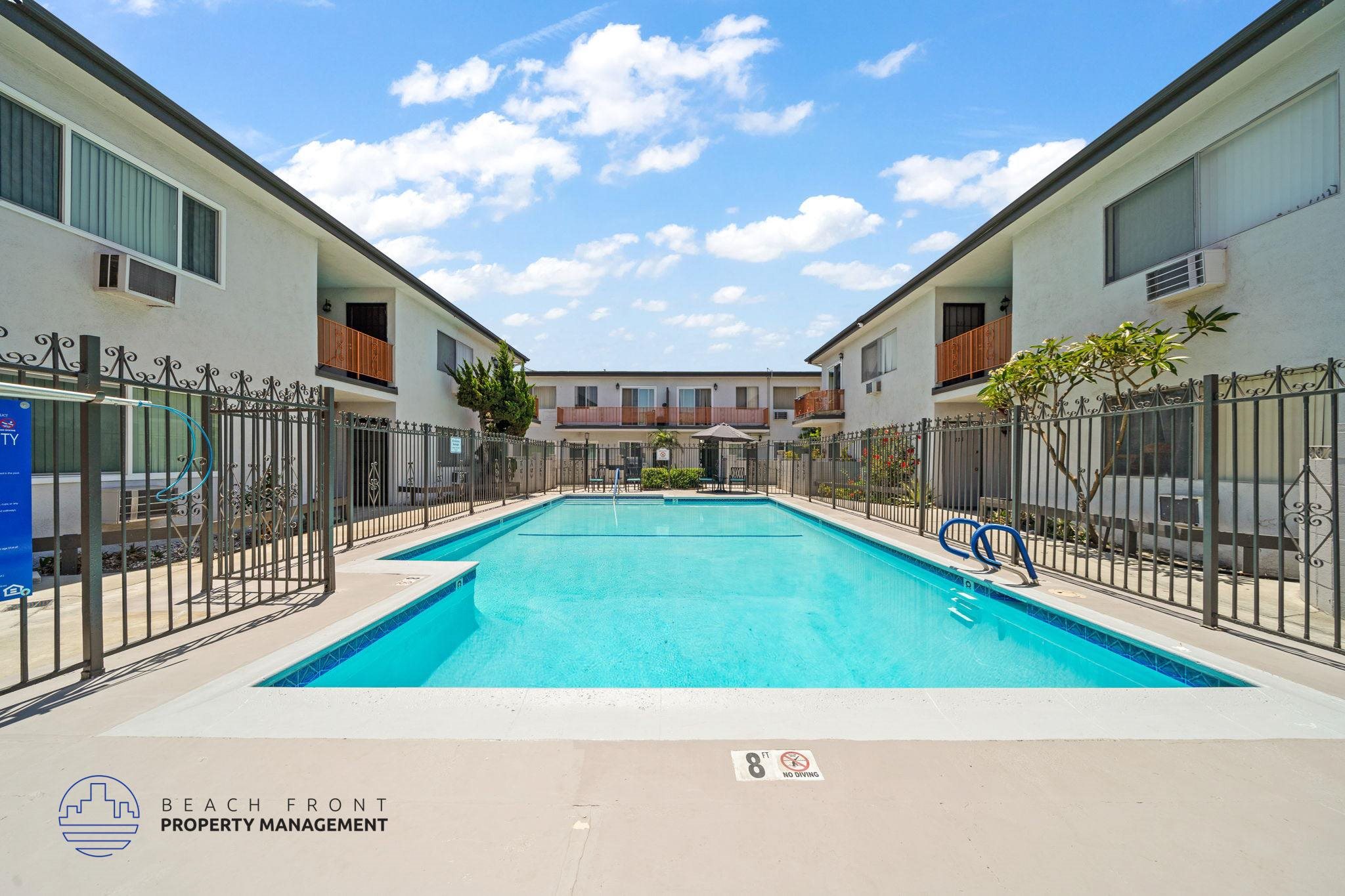 A swimming pool surrounded by a fence and buildings.