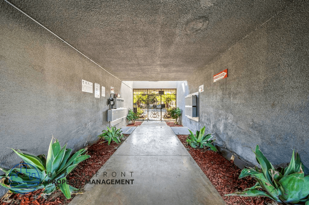 A concrete hallway with a red sign that says Front Management.