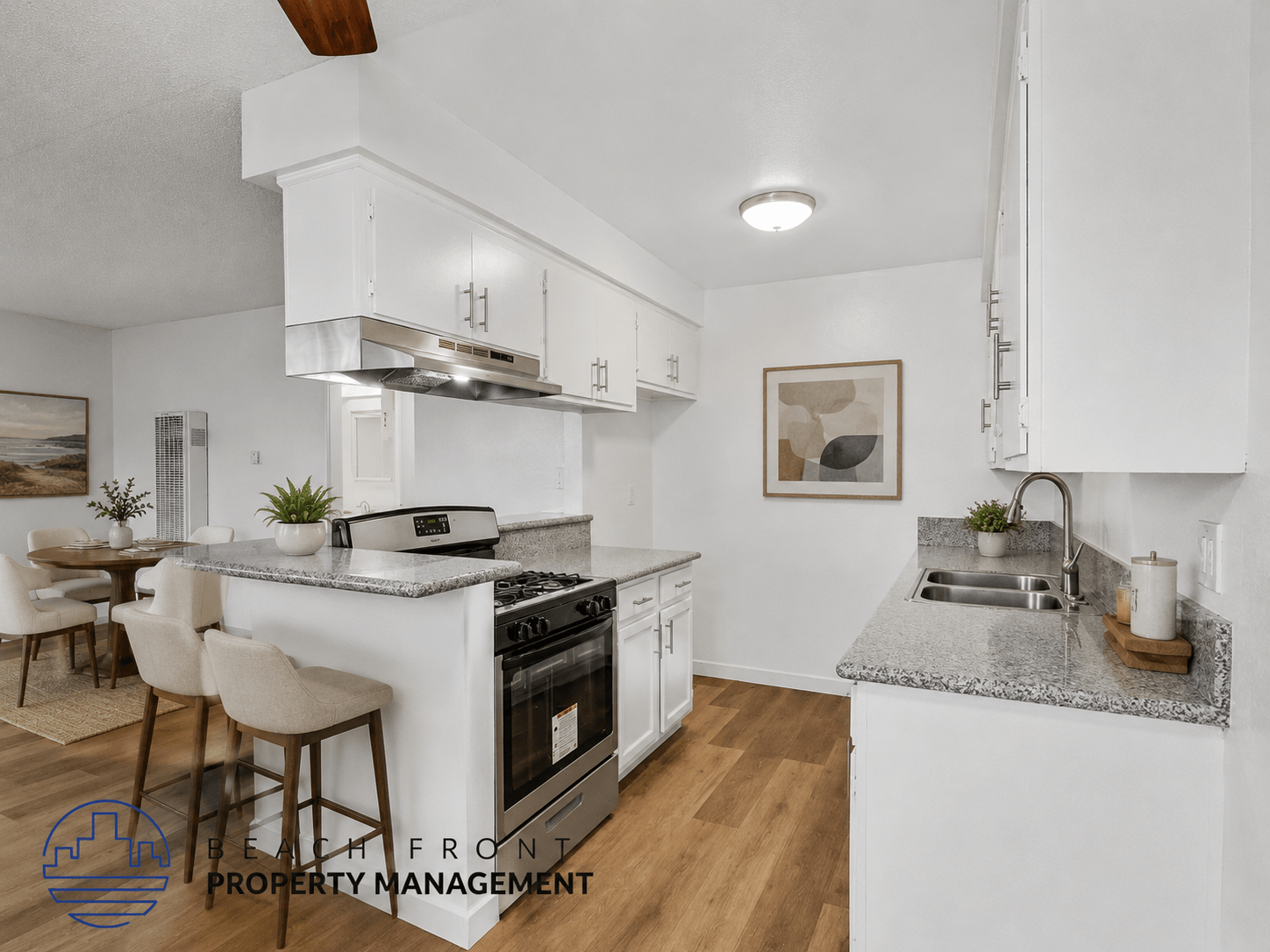 A modern kitchen with white cabinets and a marble countertop.